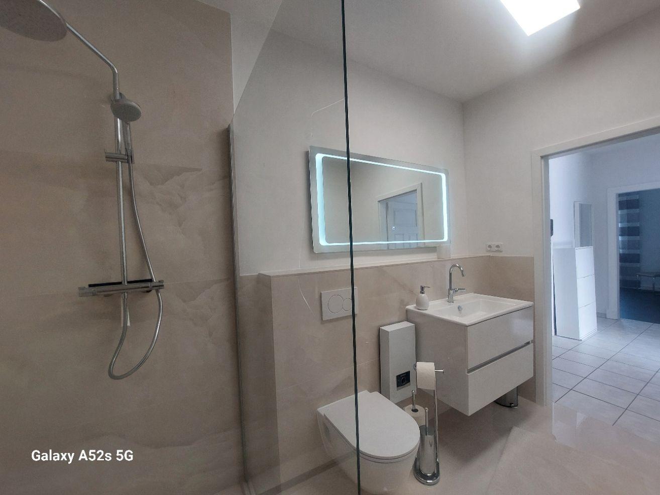 Badezimmer mit Dusche, Waschbecken und Toilette