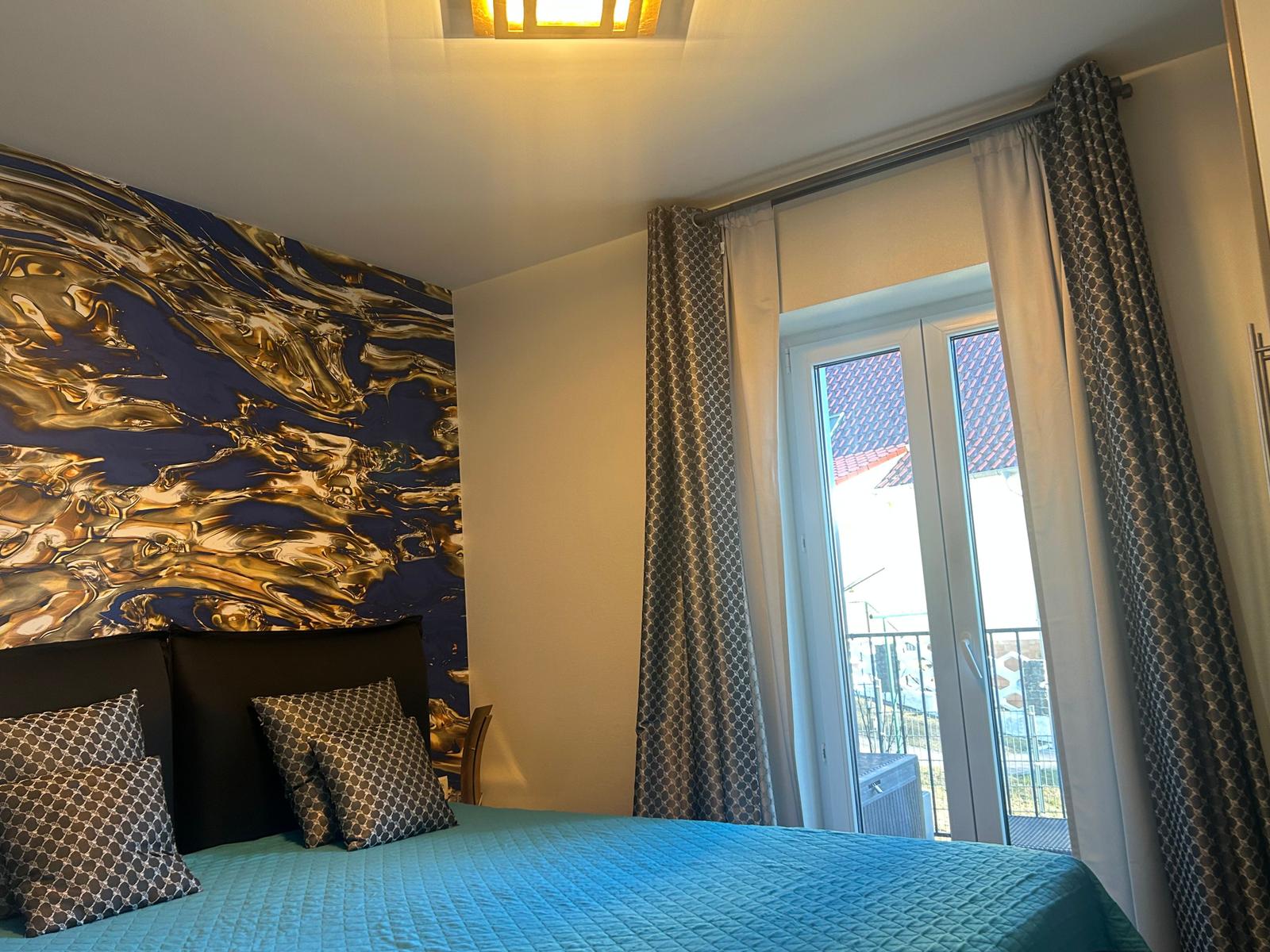 1.Schlafzimmer mit Boxspringbett und Zugang zum Balkon