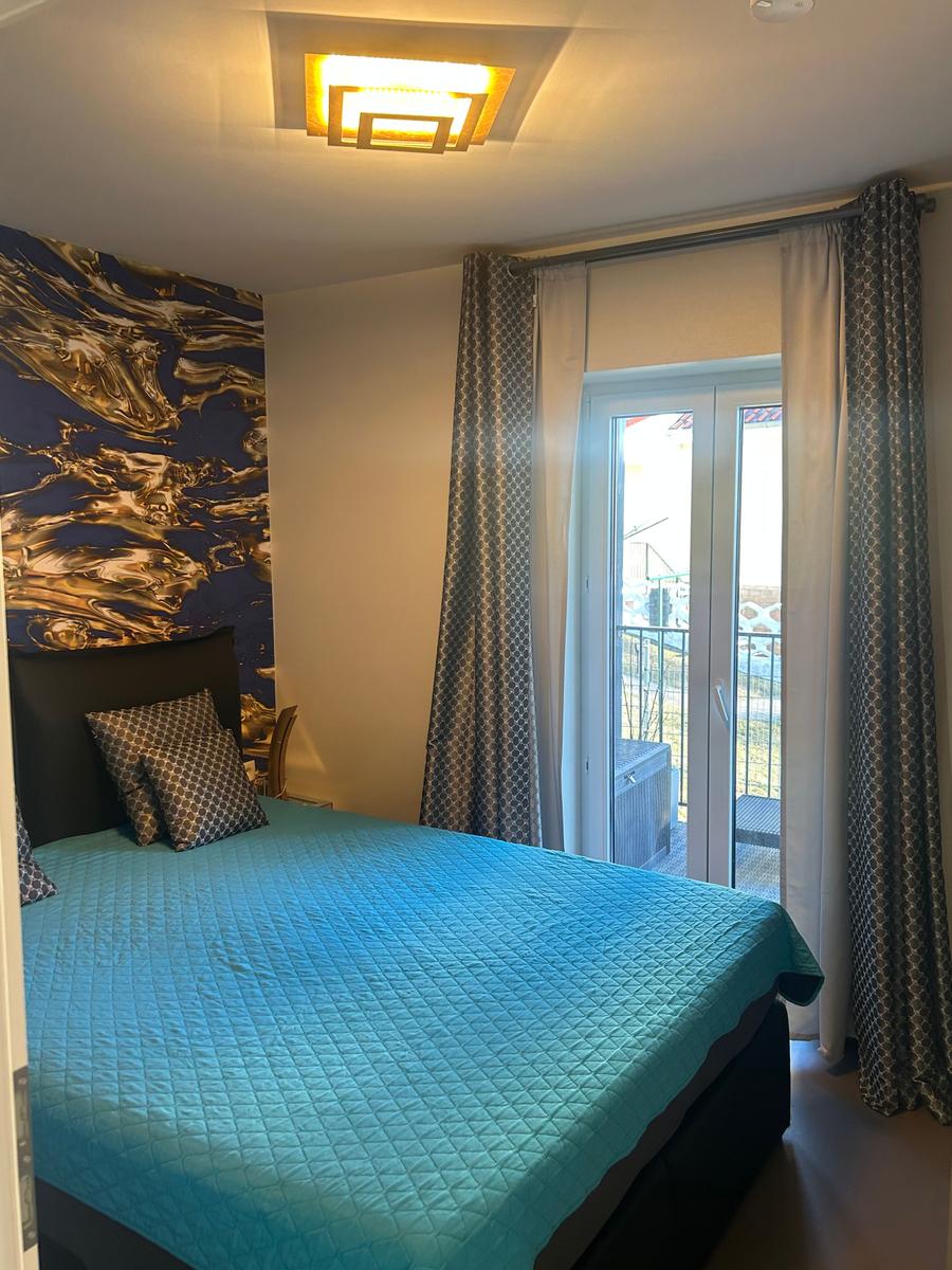 2.Schlafzimmer mit Boxspringbett und Zugang zum Balkon