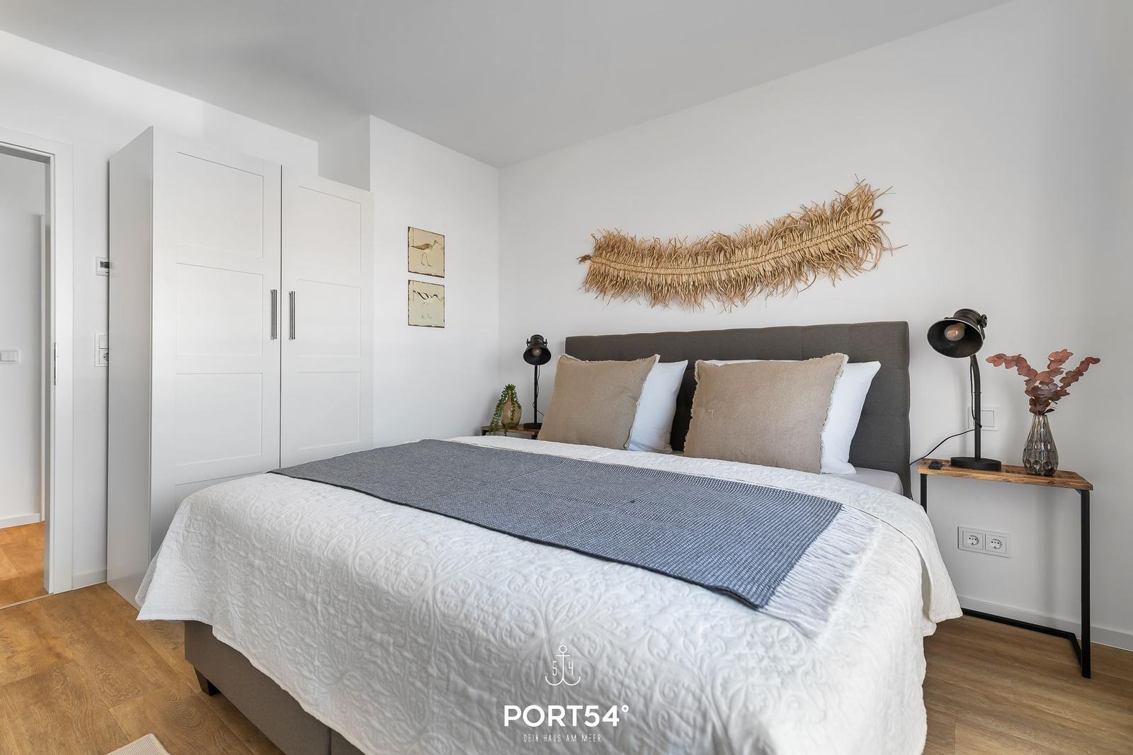 Schlafzimmer mit Bett, Nachttischen und Kleiderschrank.