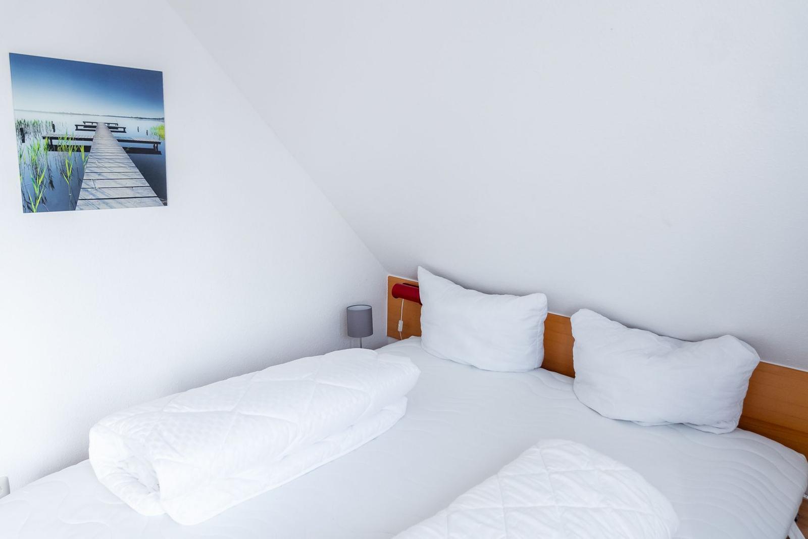 Schlafzimmer mit Doppelbett, Wandbild und Nachttisch