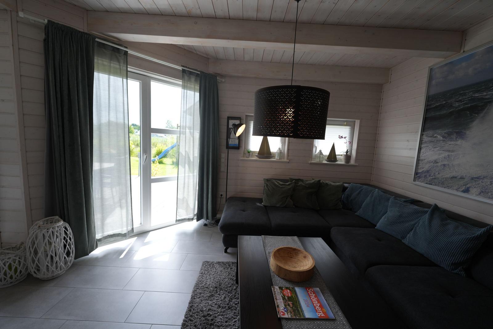 Wohnzimmer mit Sofa, Couchtisch und Blick auf Garten