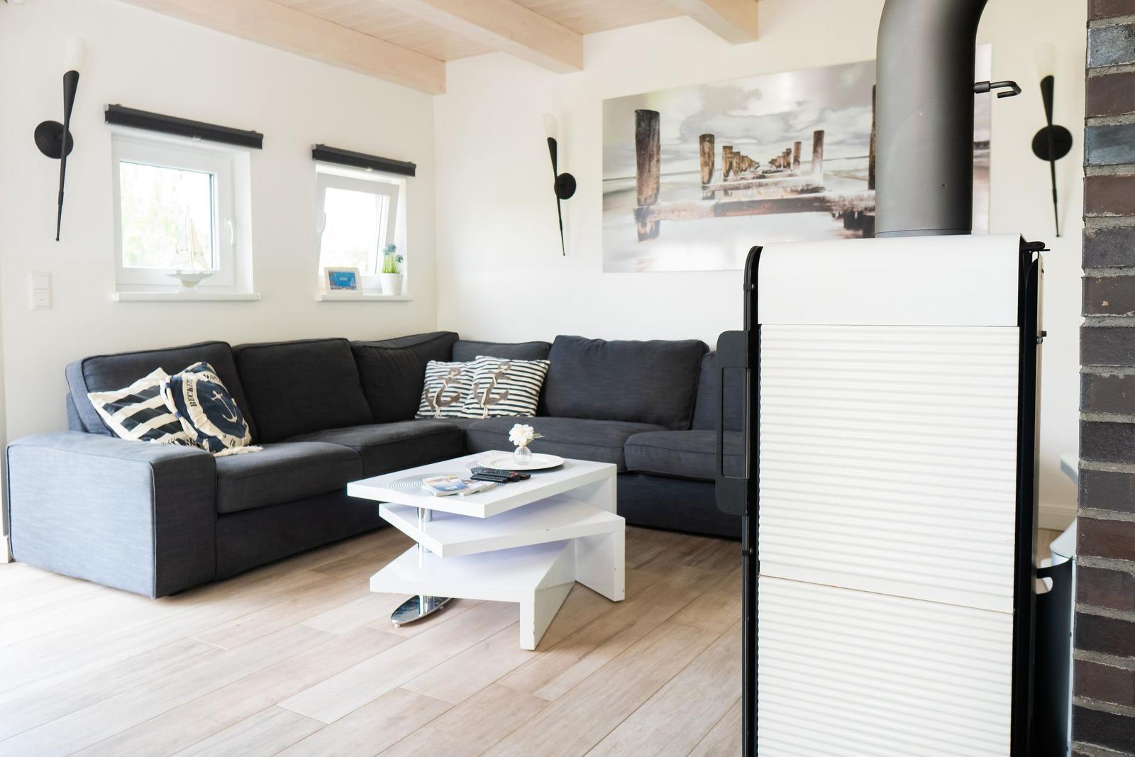 Wohnzimmer mit grauem Sofa, weißem Couchtisch und Kamin