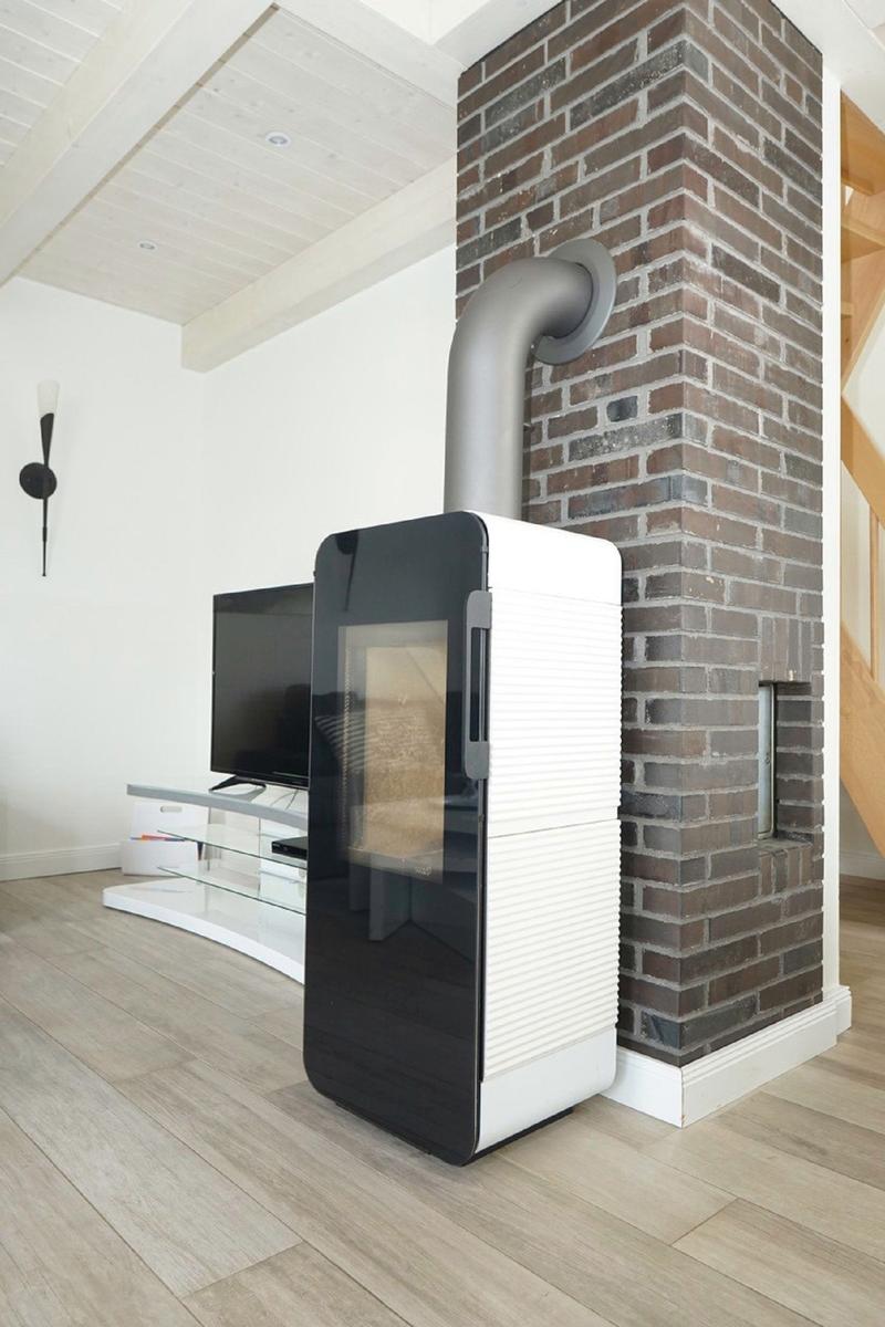 Moderne Kamineinheit neben Backsteinmauer mit Fernseher und Holzboden