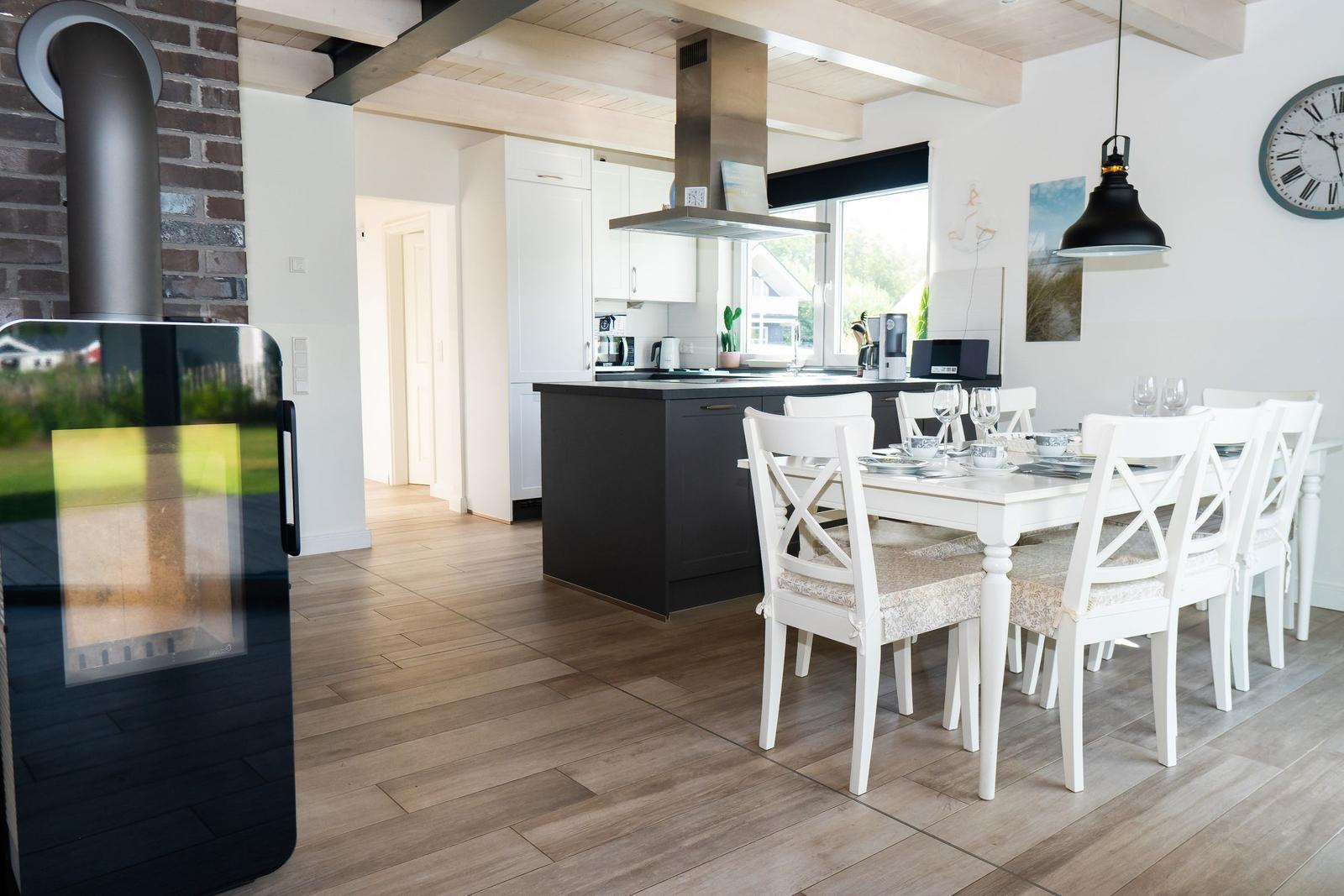 Küche mit Esstisch, Holzboden und Kaminofen