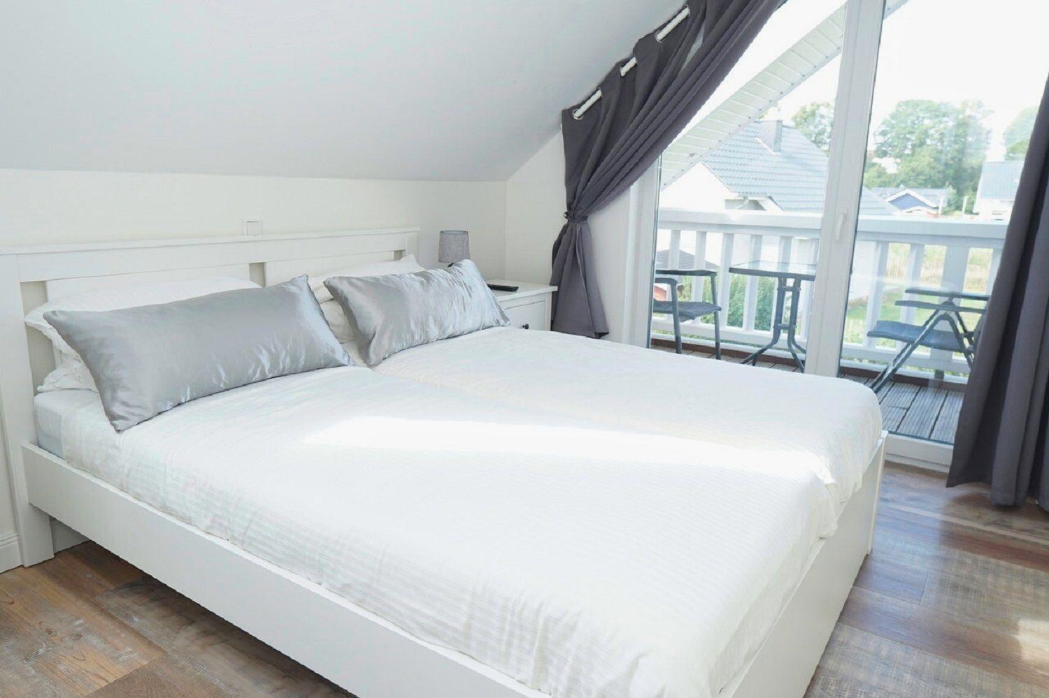 Schlafzimmer mit Doppelbett und Balkonansicht