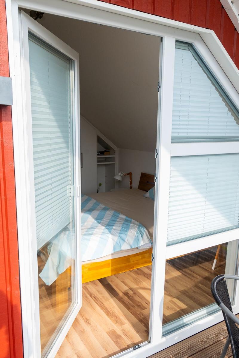 Schlafzimmer mit Bett und Schrank hinter Glastür