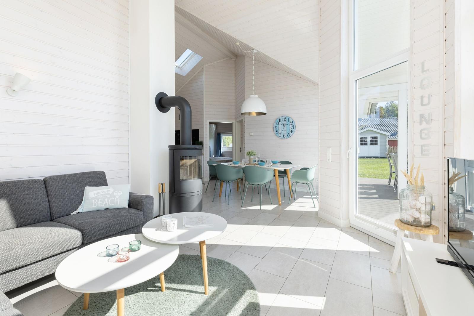 Wohn- und Essbereich mit Sofa, Kamin und Tisch mit Stühlen.