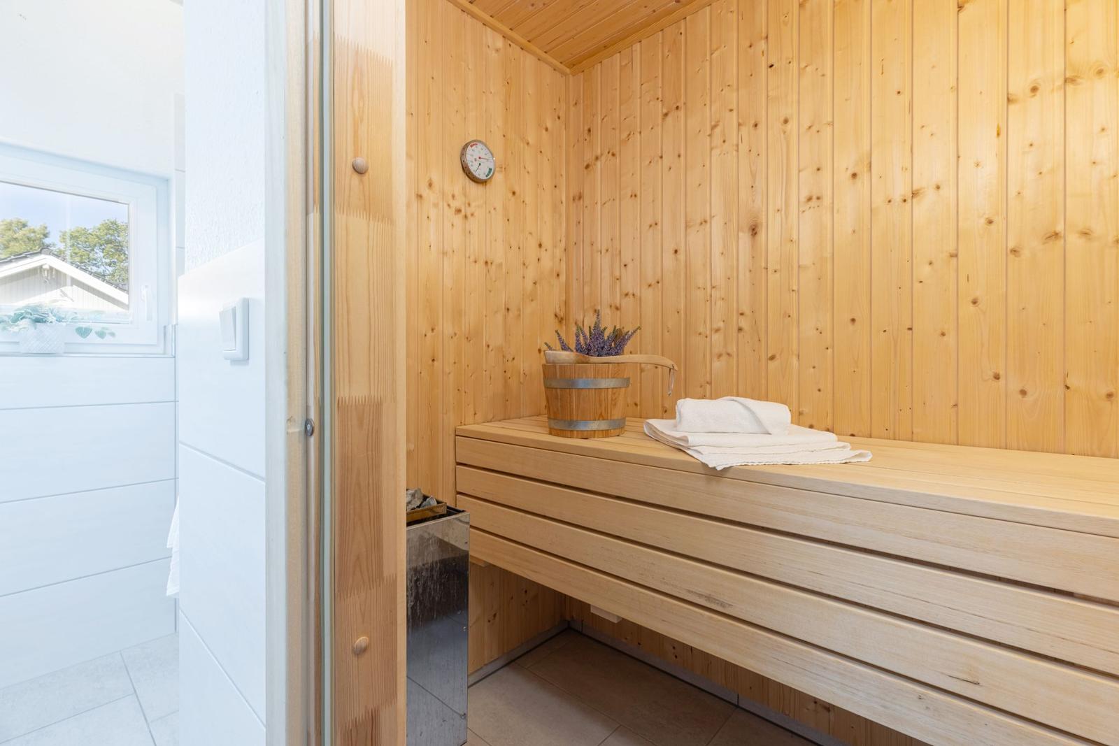 Holzsauna mit Bank, Waschbecken und Fenster
