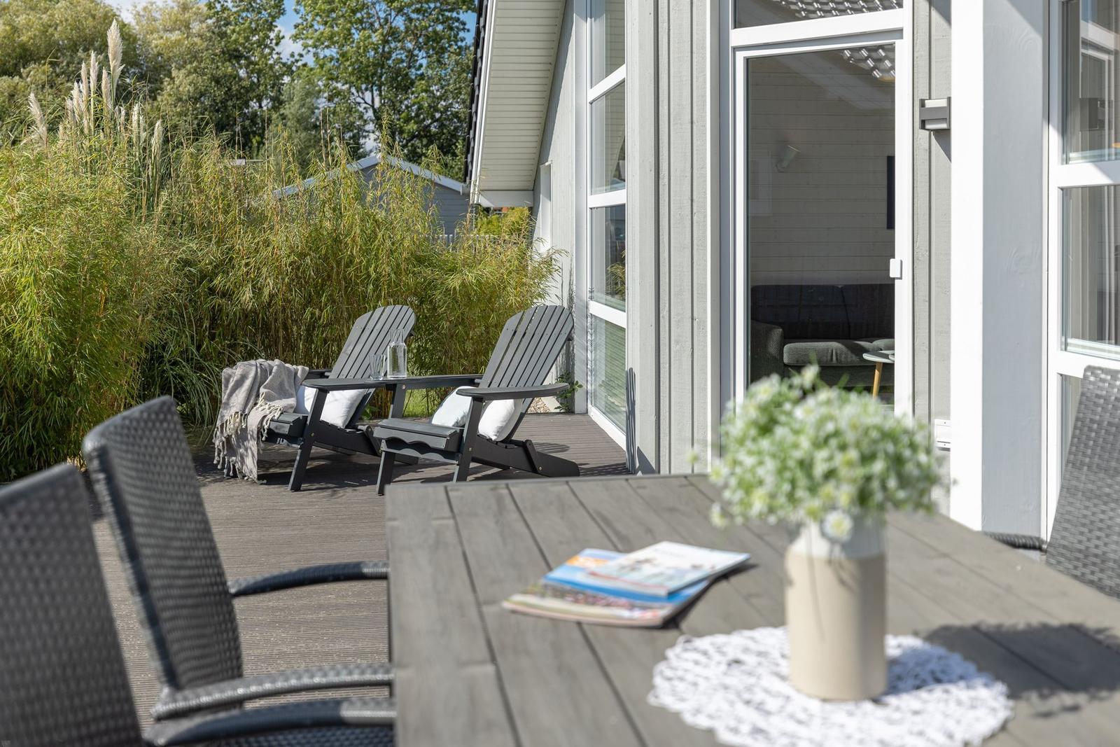 Terrasse mit Tisch, Stühlen und Blick in das Haus.
