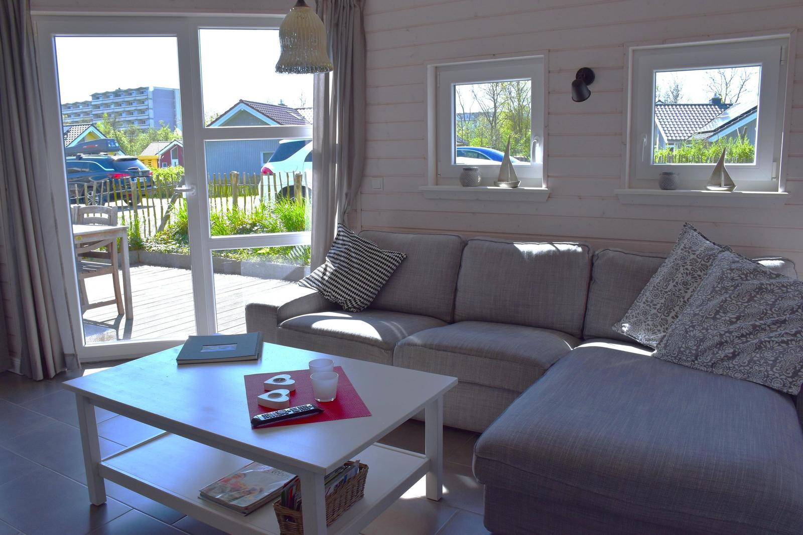 Wohnzimmer mit Sofa, Couchtisch und Blick auf Terrasse