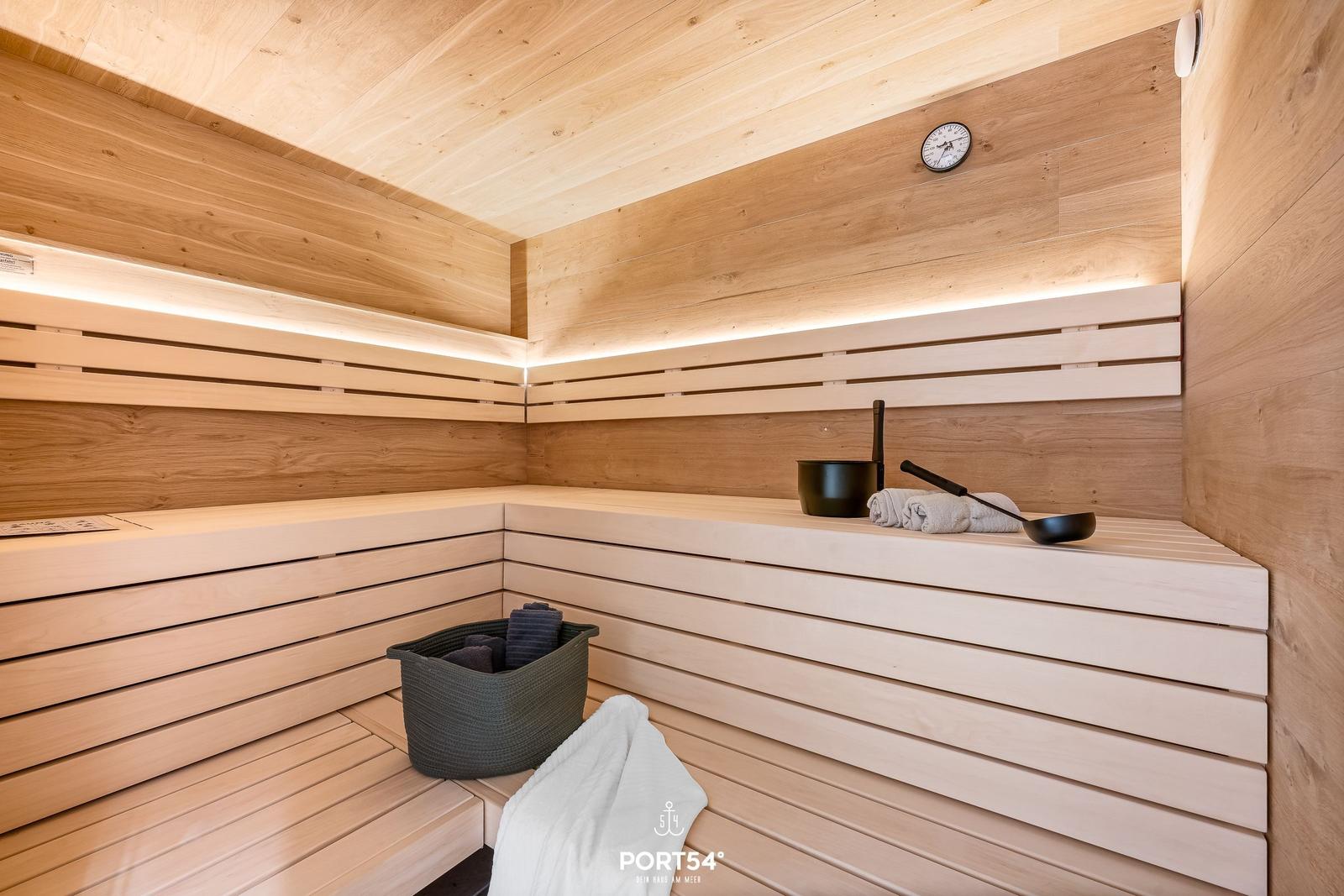 Sauna mit Holzbank, Thermometer und Badetüchern