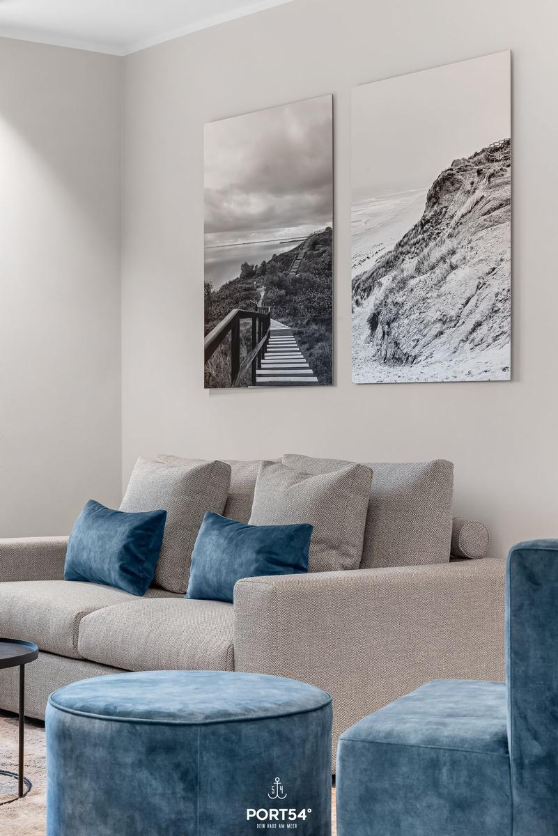 Wohnzimmer mit Sofa, Kissen und Wandbildern