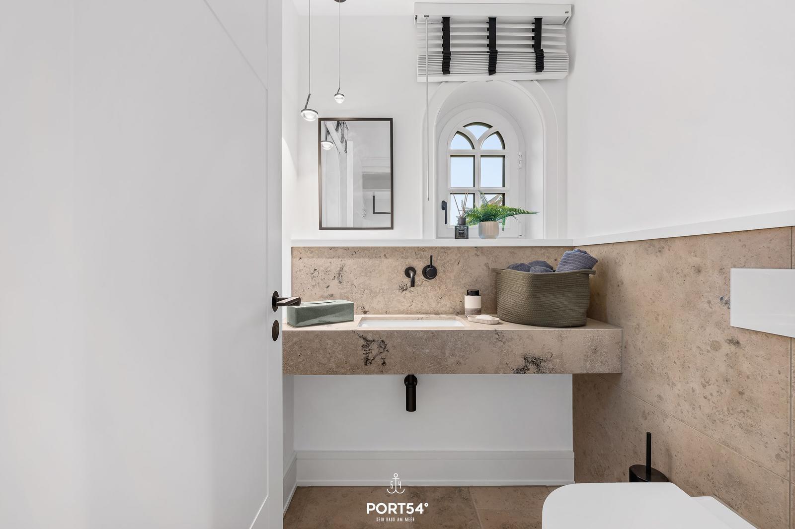 Bad mit Waschbecken, Spiegel und Badezimmerfenster.