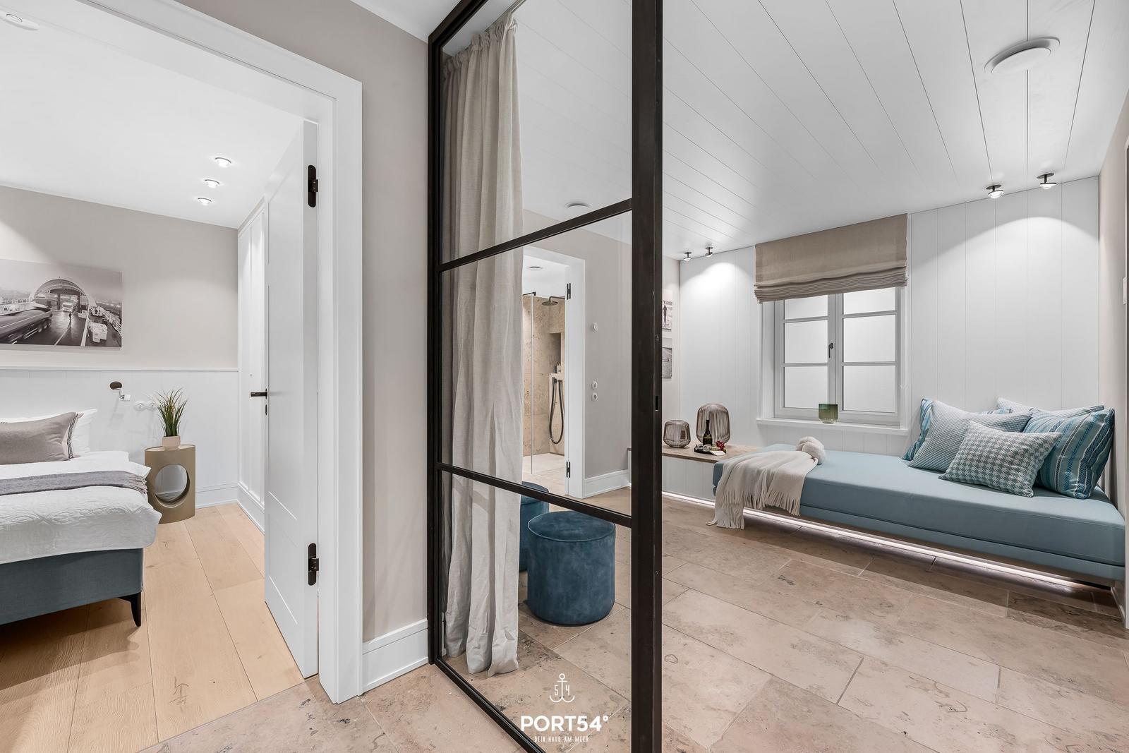 Schlafzimmer mit Blick auf Bad und Sitzecke mit Fenster