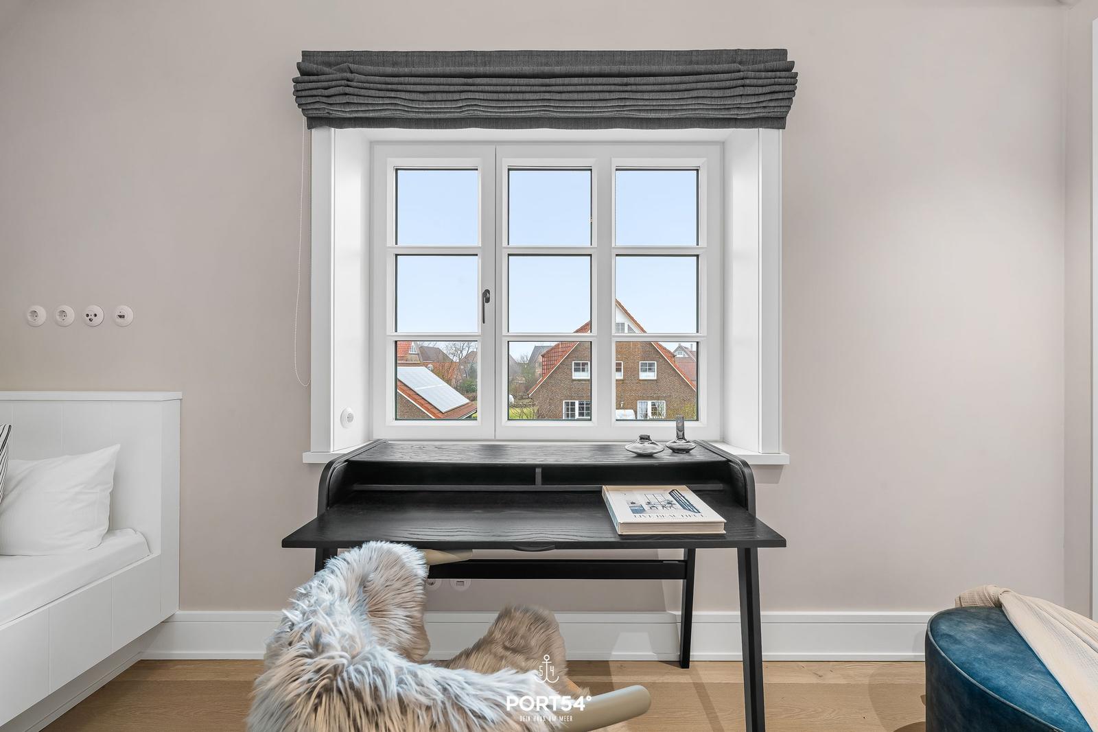 Schreibtisch unter Fenster mit Blick auf Dächer