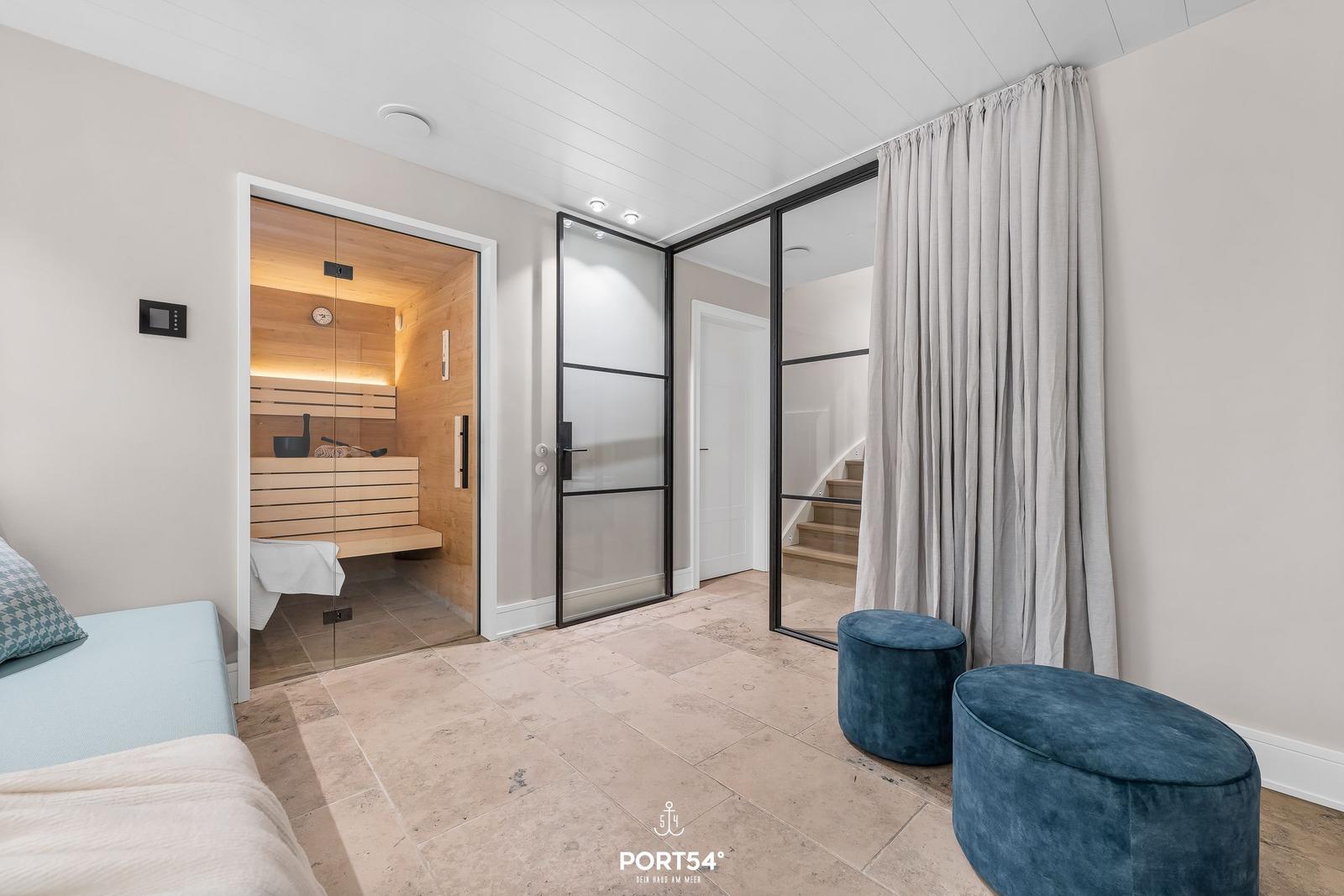 Sauna, Glaswand und blaue Sitzkissen im Raum