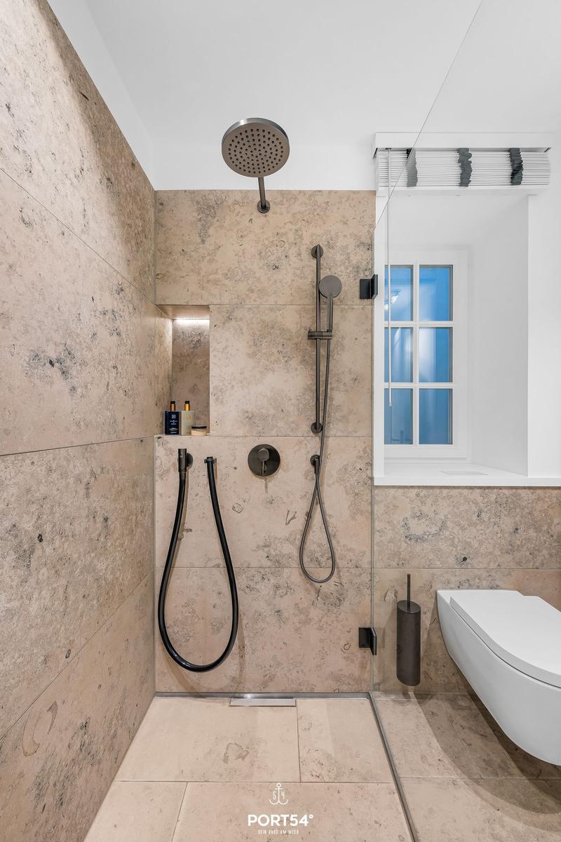 Dusche mit Duschbrause und Fenster im Bad