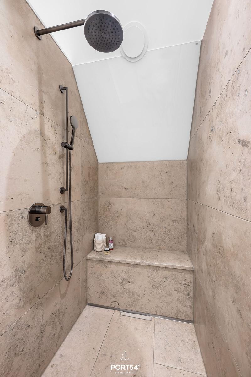 Duschkabine mit Steinwand und Sitzbank