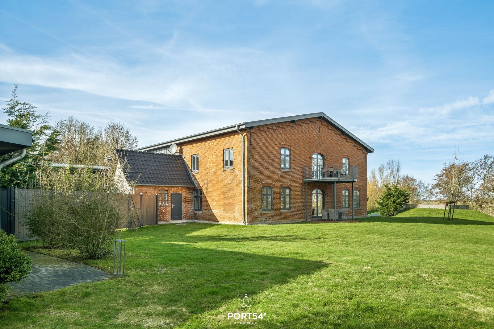 Rotes Backsteingebäude mit Balkon und Garten