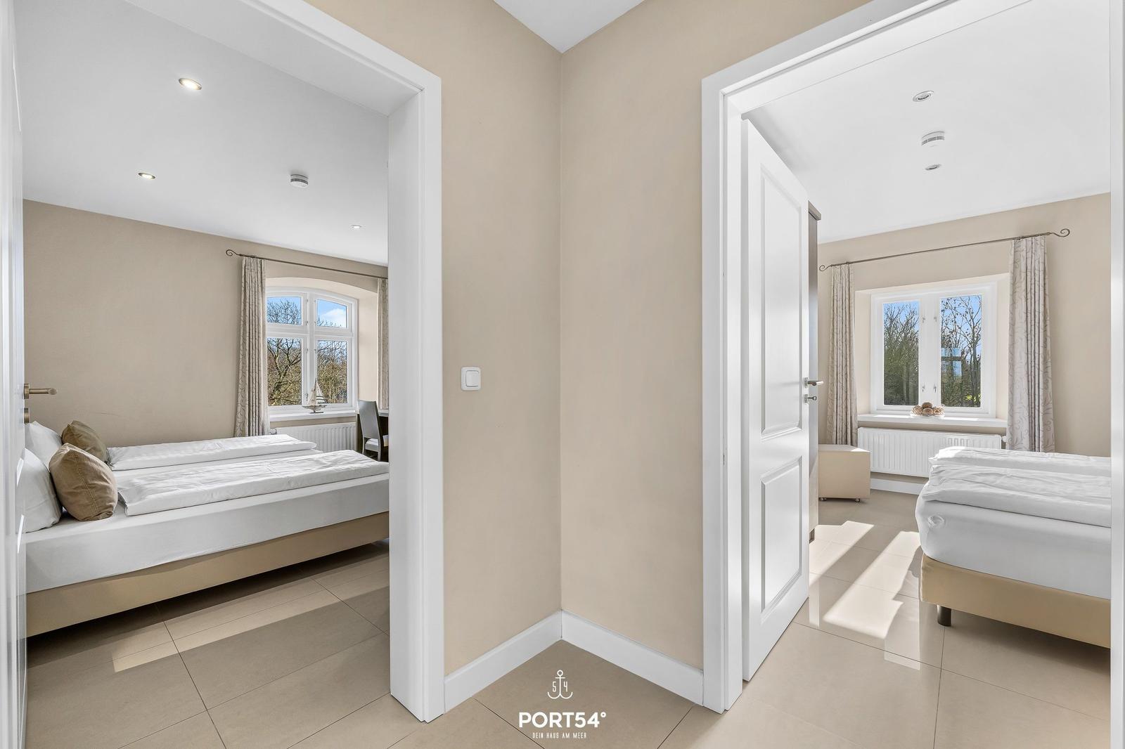 Zwei Schlafzimmer mit Betten und Fenstern sind sichtbar.