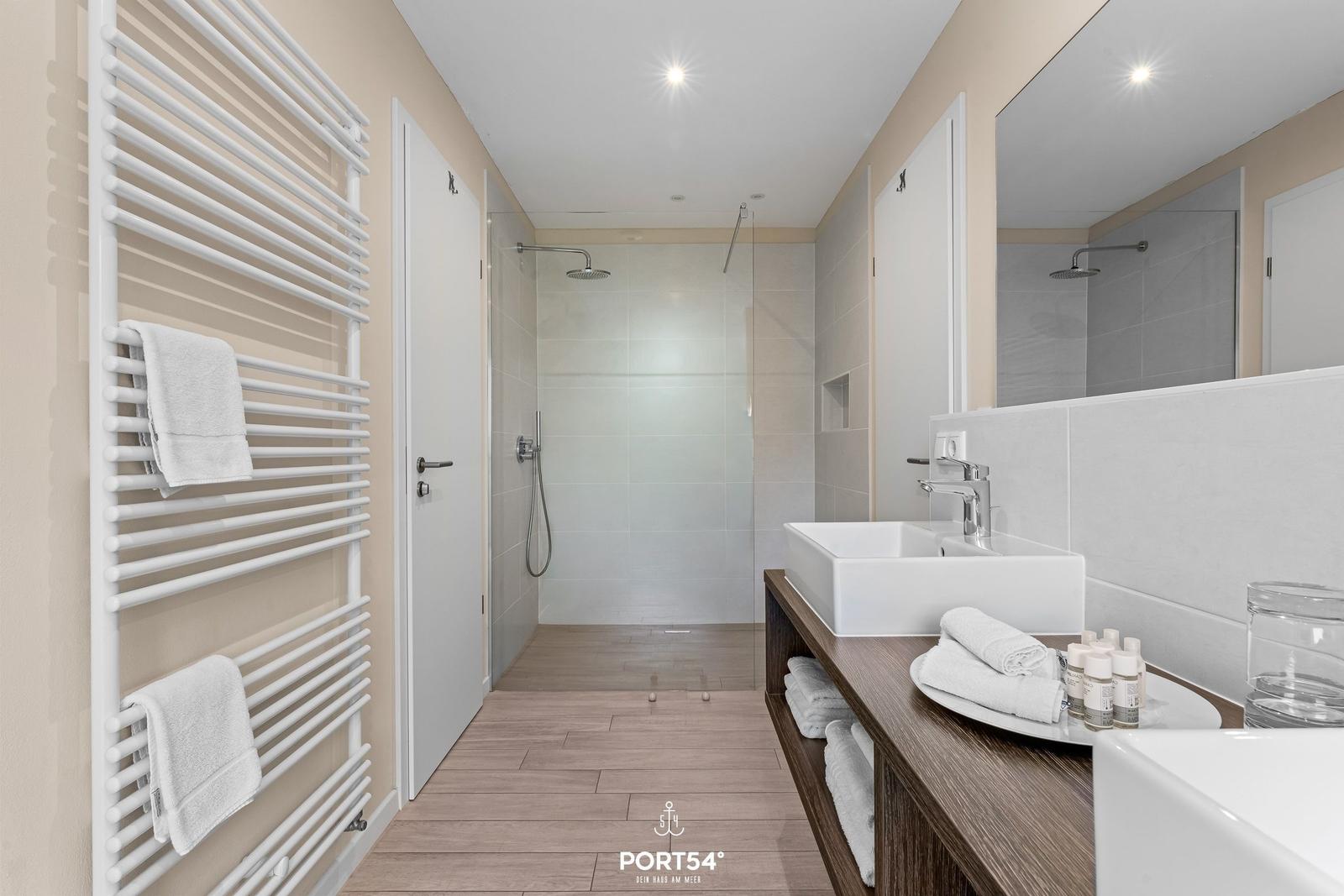 Badezimmer mit Dusche, Waschbecken und Handtuchhalter