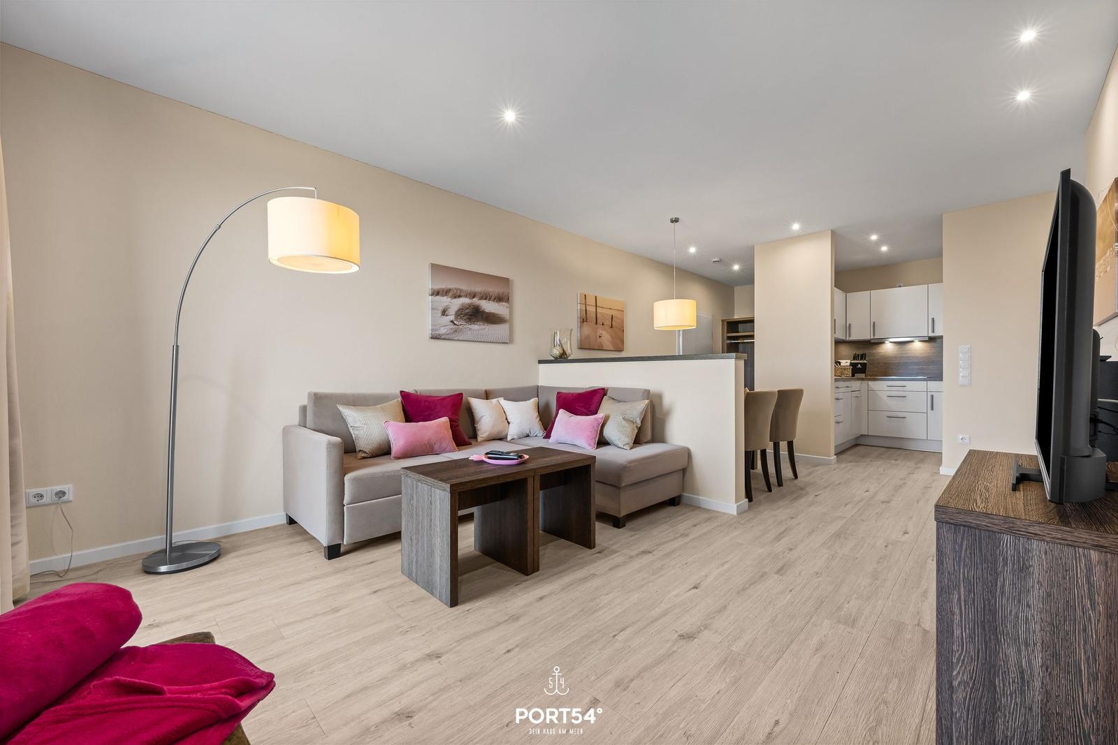 Wohn- und Essbereich mit Sofa, Tisch und Küchenbereich.