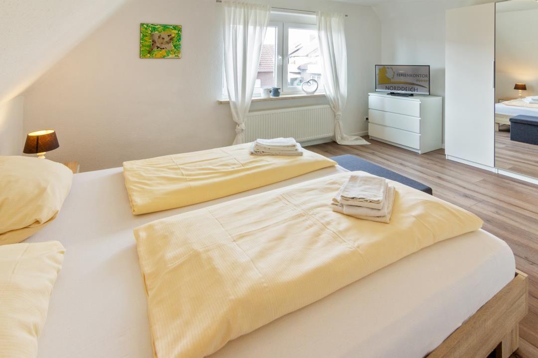 Zimmer mit Doppelbett, Fenster, Schrank und Spiegel