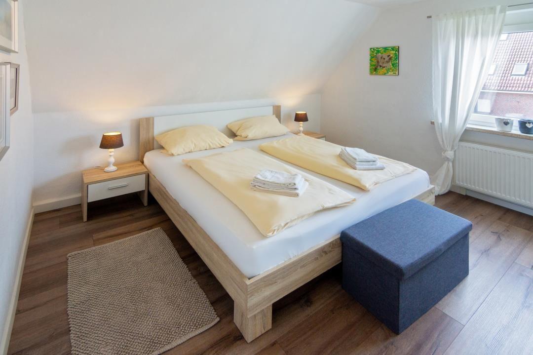 Schlafzimmer mit Doppelbett, Nachttisch und Fenster