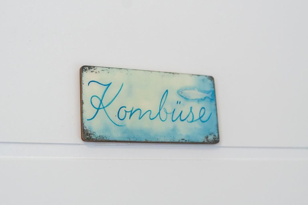 Schild mit der Aufschrift Kombüse und Fischmotiv