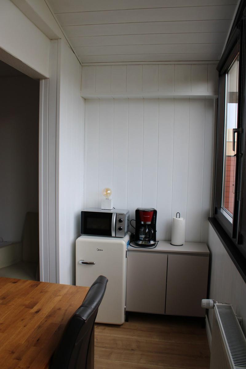 Kitchen area with microwave, coffee maker, and refrigerator.
