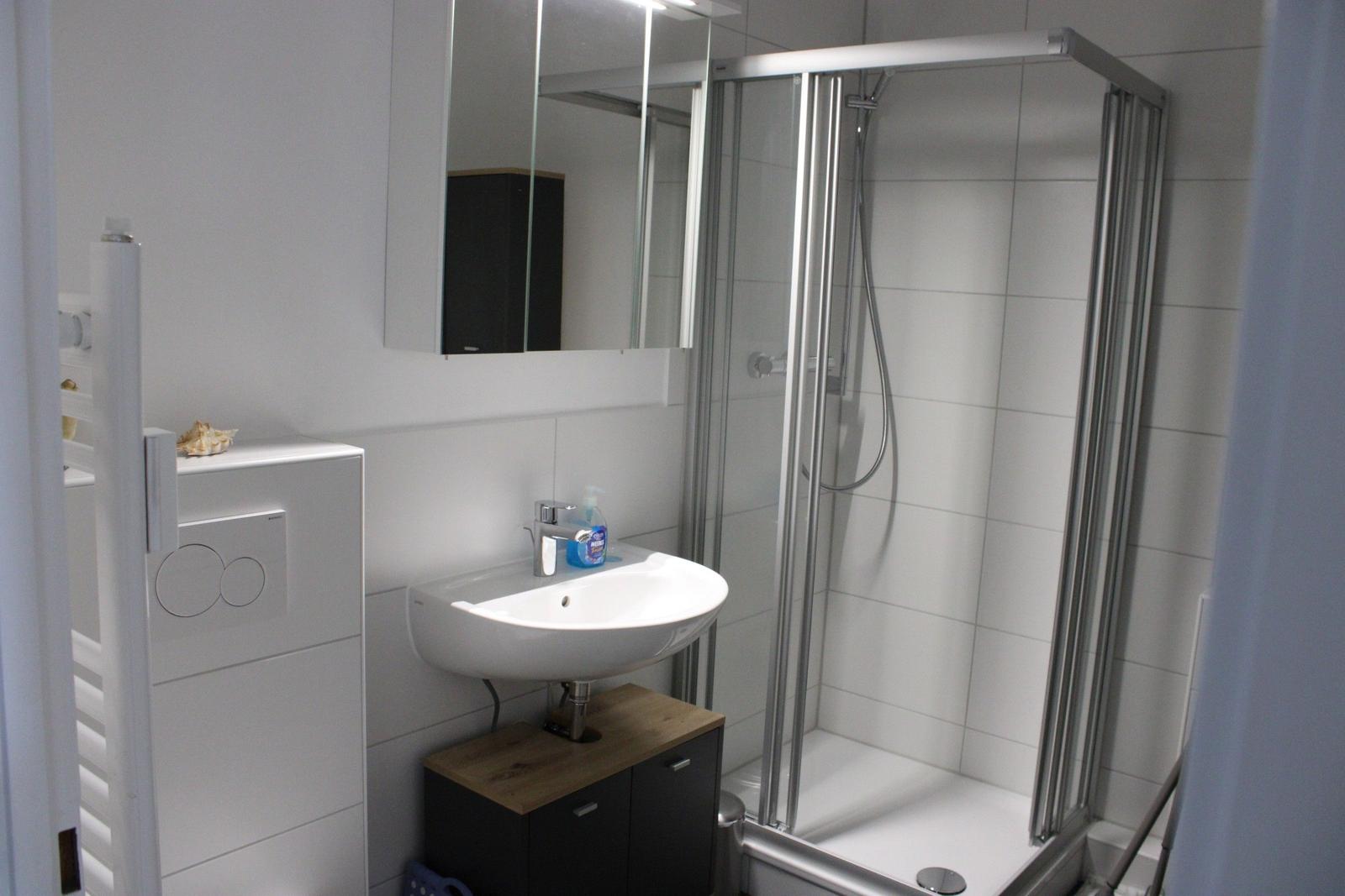 Bathroom with shower, sink, and mirror