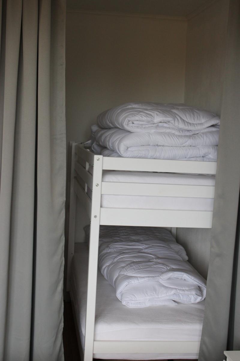 Double bed with white mattress and bedding