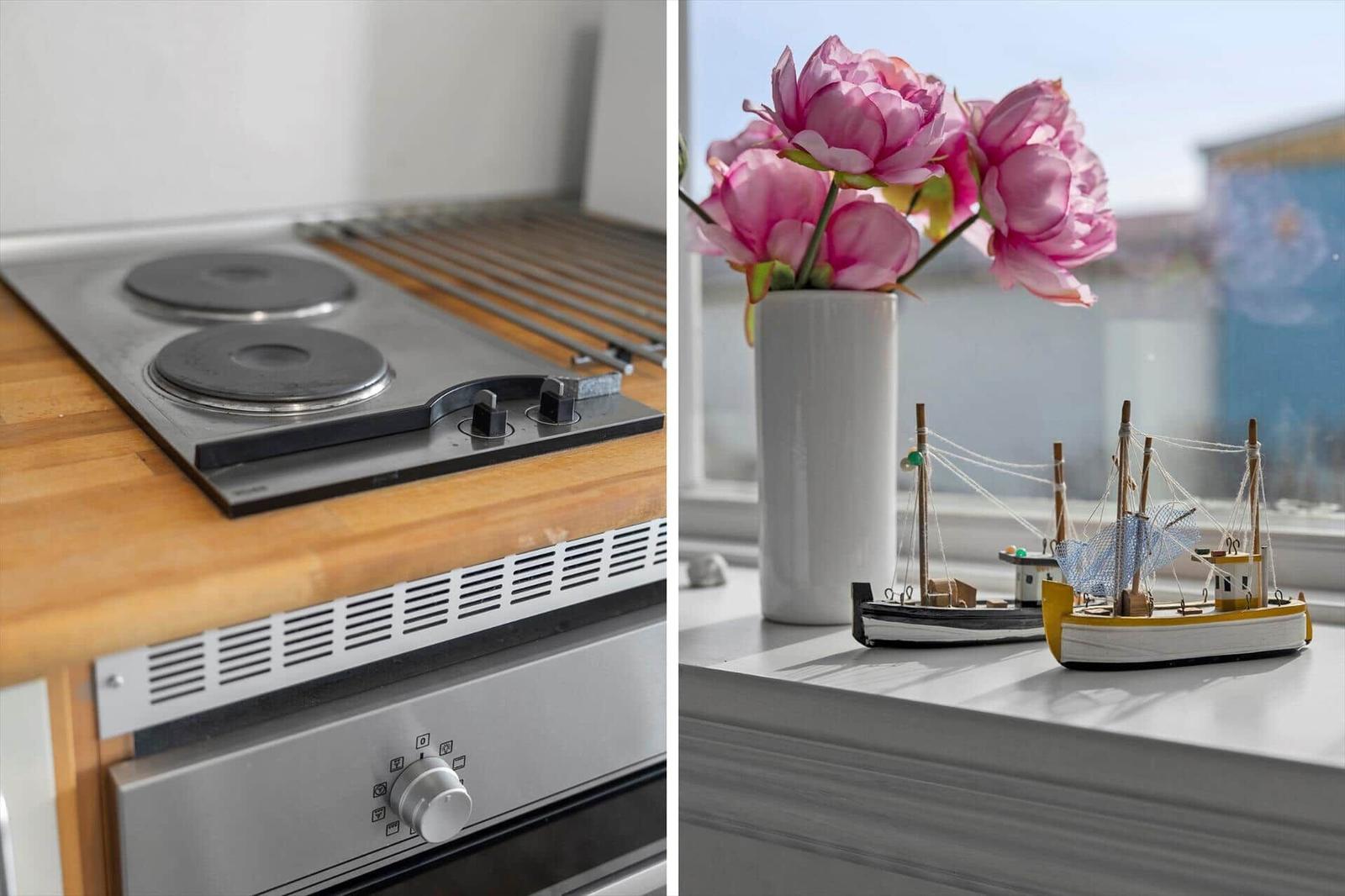Kitchen with stove and window with flowers and ship models