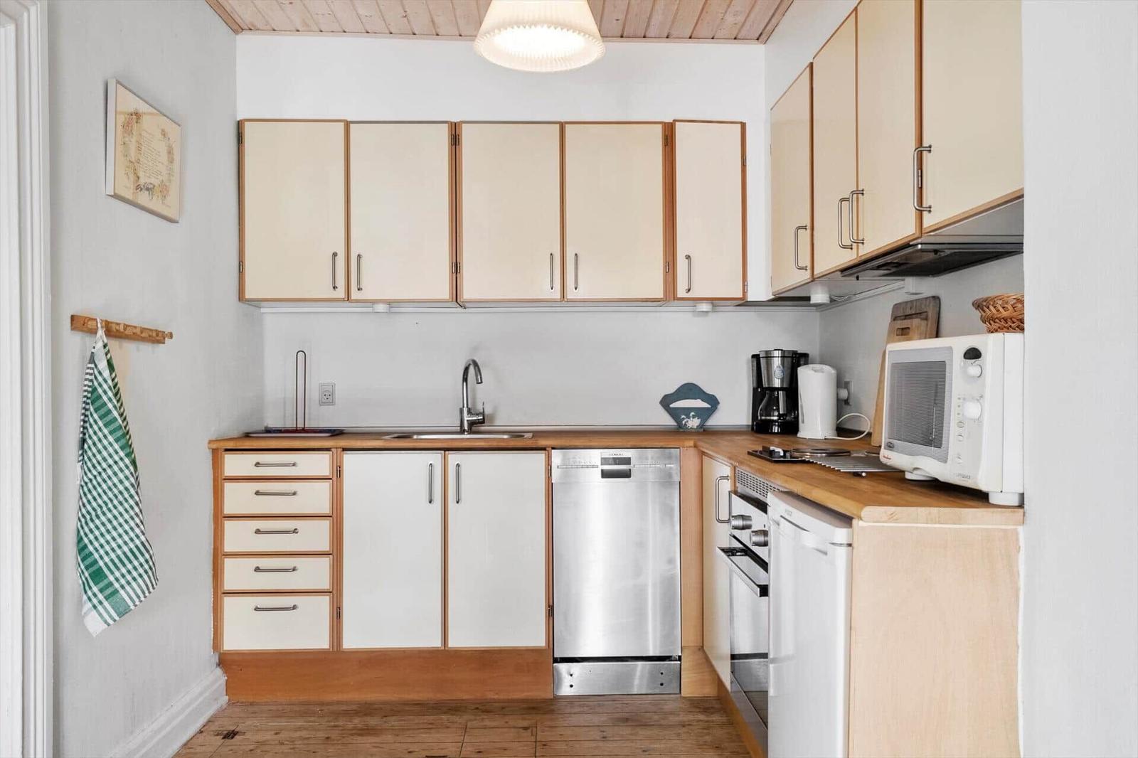 Kitchen with wooden surfaces, sink, dishwasher, and microwave.