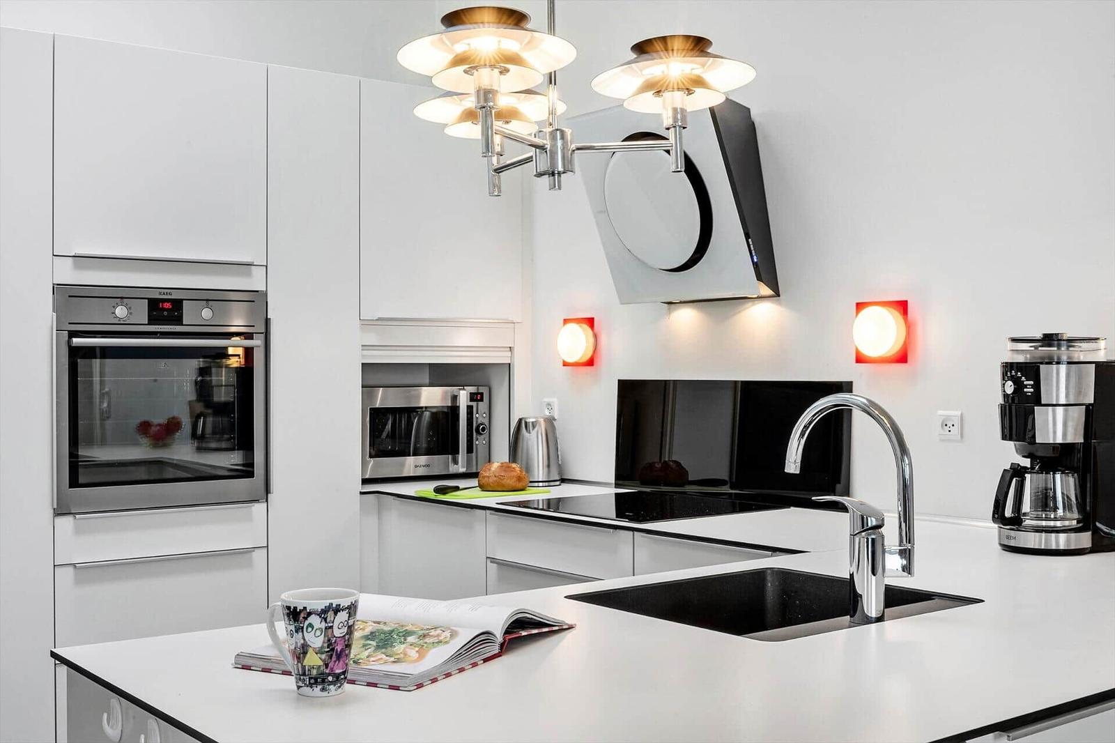 Modern kitchen with stainless steel appliances and white countertop.