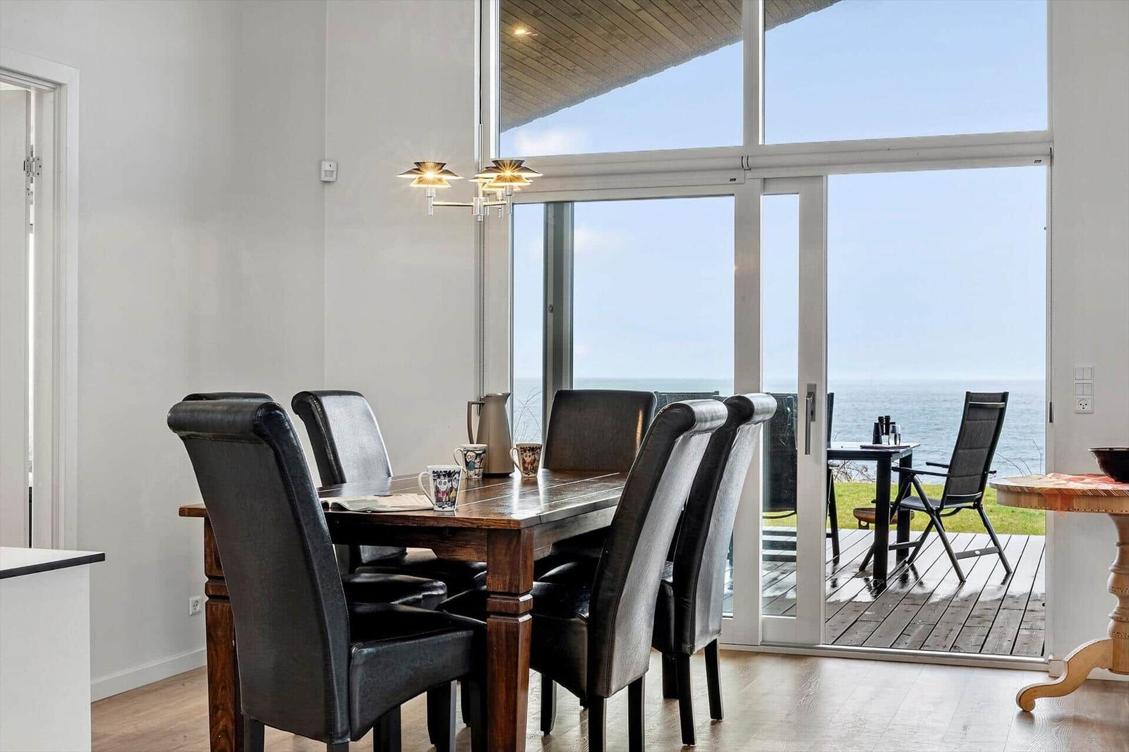 Dining room with sea view. Table with chairs and terrace.