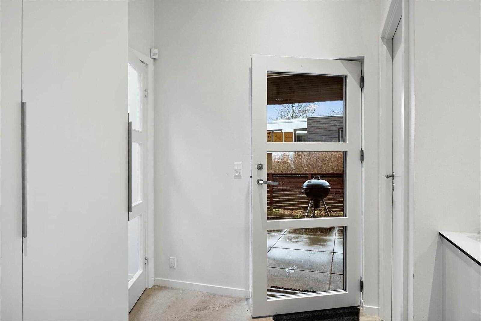 Behind the door is a grill on the patio.