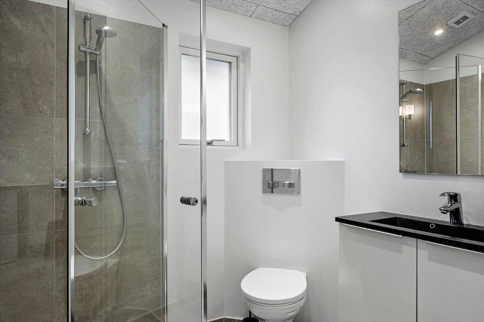 Bathroom with shower, toilet, and sink.