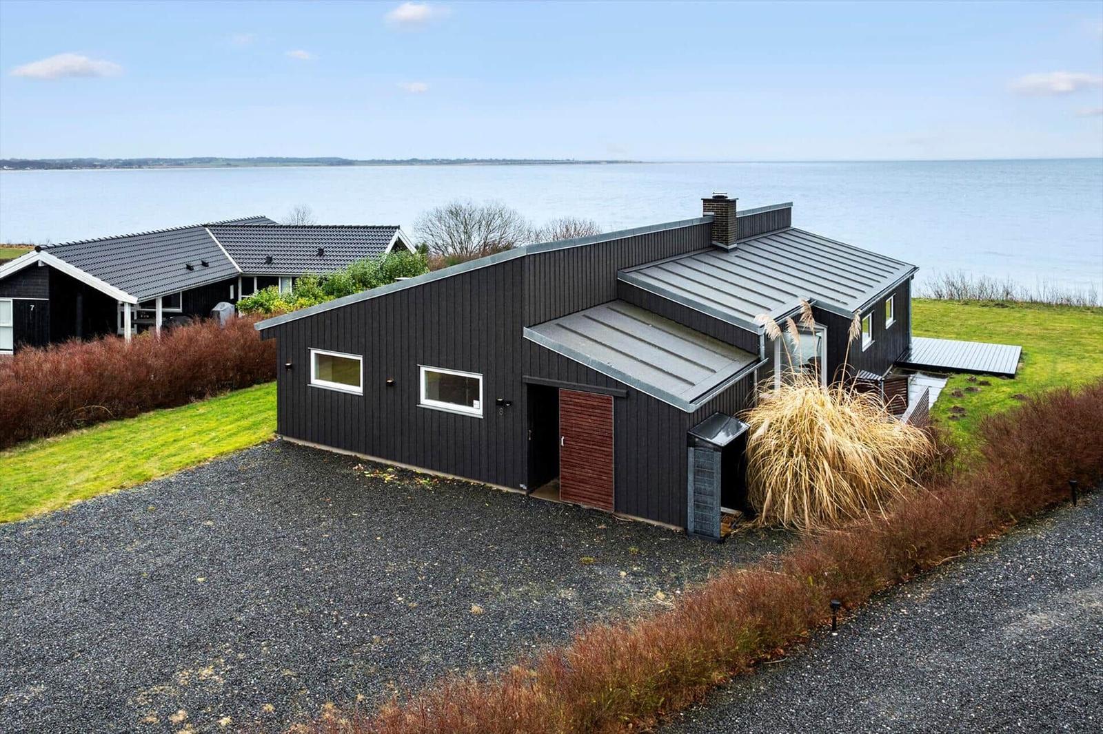 Modern villa with sea view and garden. Entrance door and terrace visible.