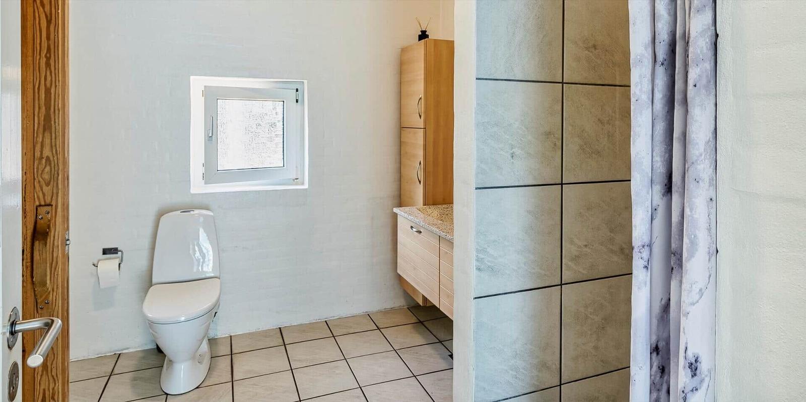 Bathroom with toilet, sink, and shower.