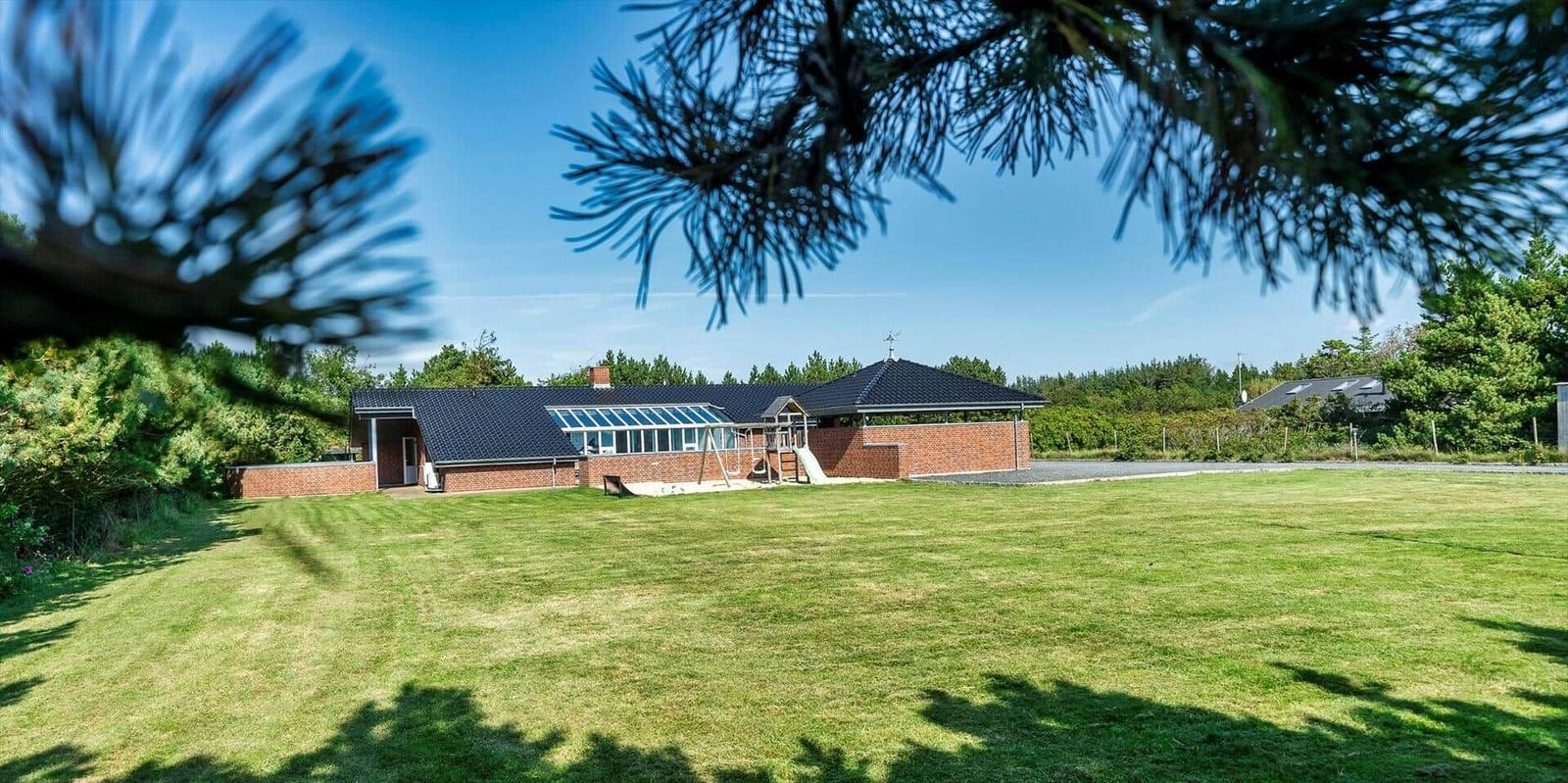 House with large garden and playground under blue sky