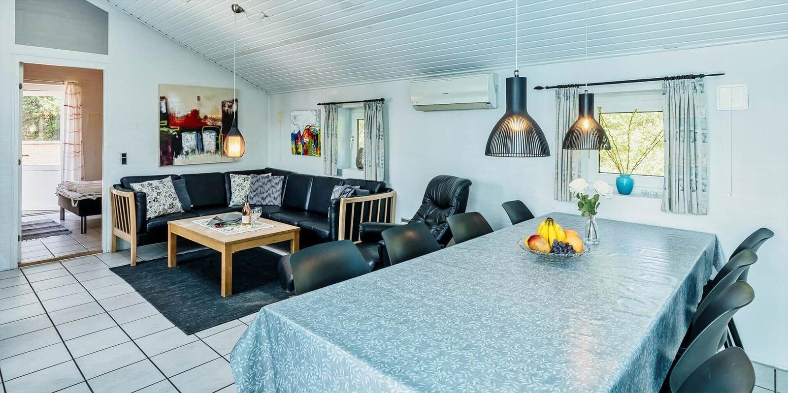 Living and dining area with sofa, dining table, and windows.