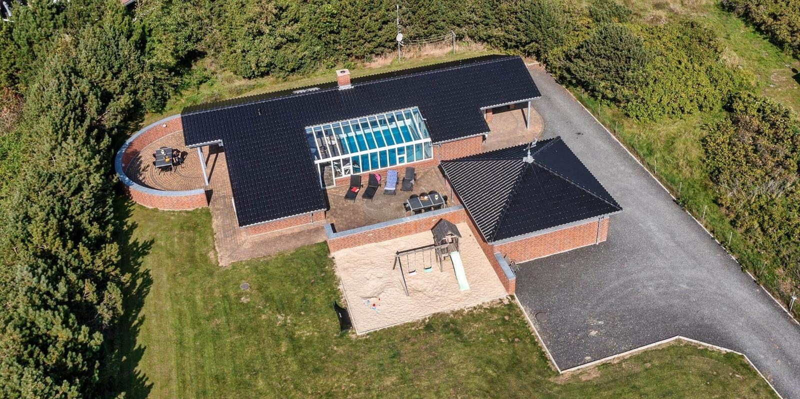 House with pool, playground, and grilling area in green surroundings.