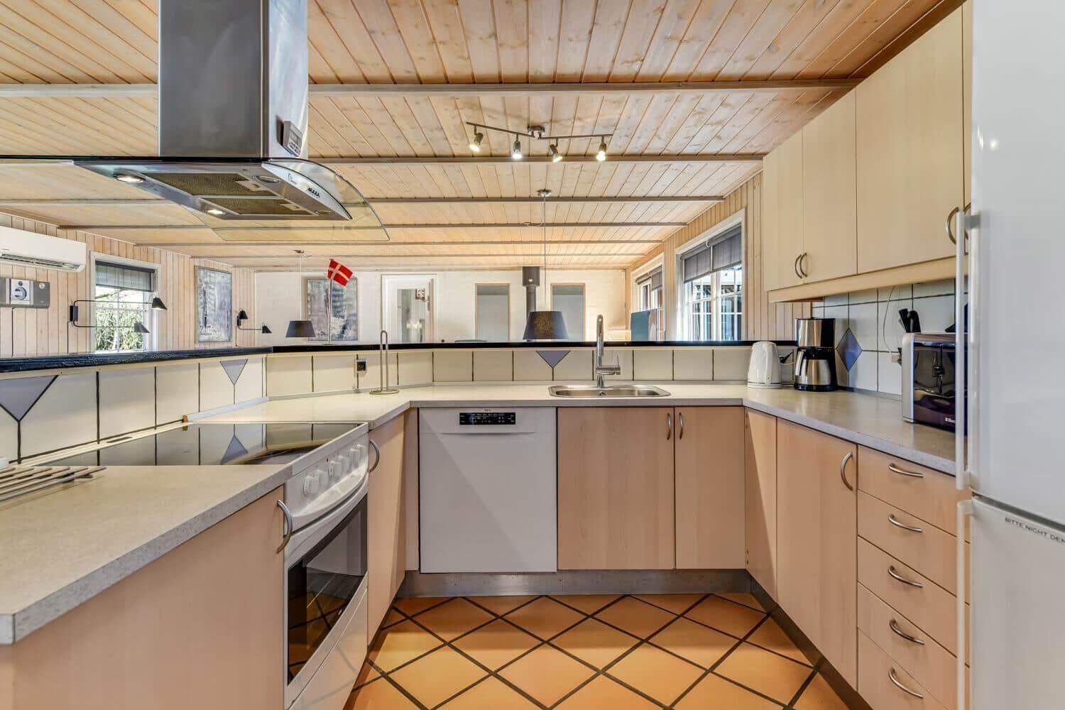 Kitchen with wooden ceiling, countertops, and appliances.