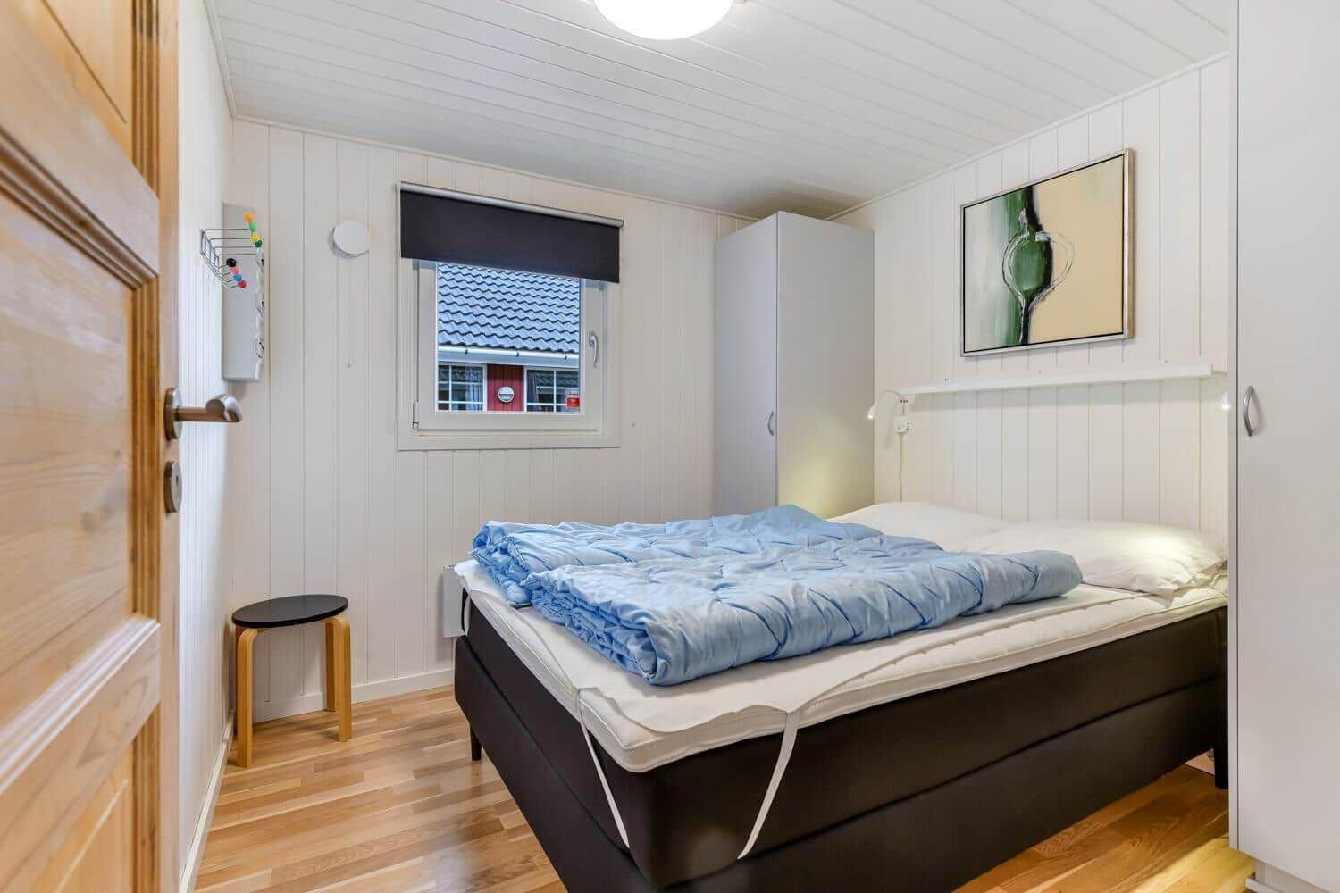 Bedroom with bed, wardrobe, and window overlooking roof