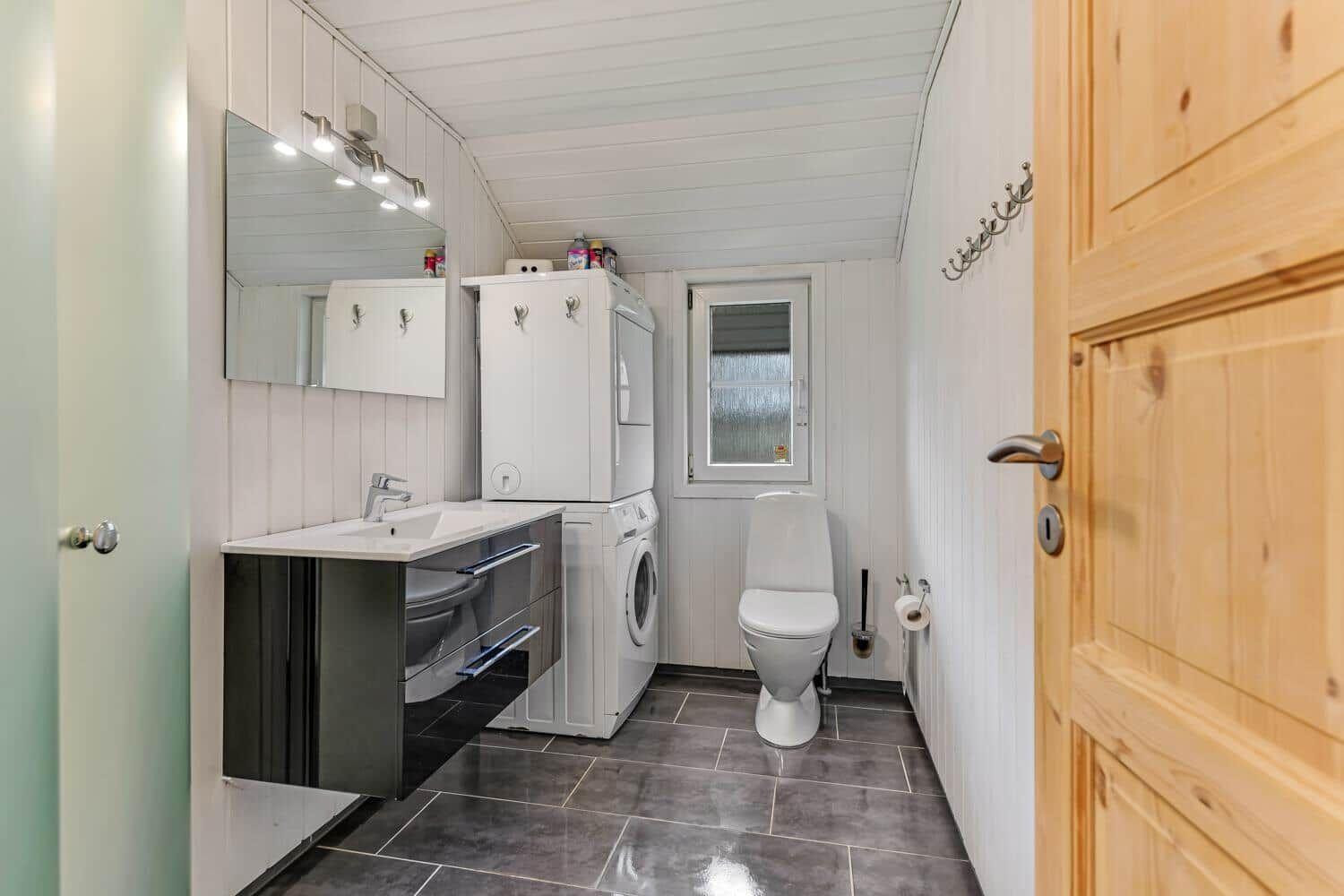 Bathroom with washing machine, toilet, and mirror