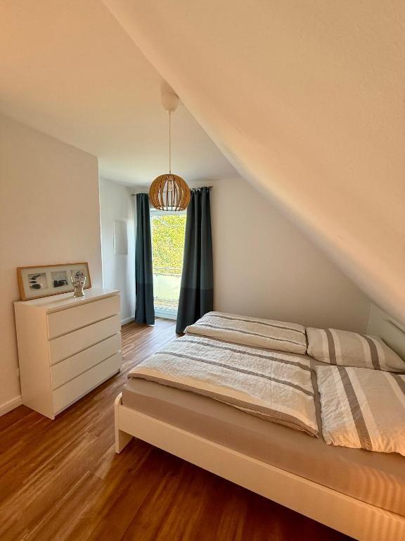 Schlafzimmer mit Dachschräge, Bett, Kleiderschrank und Fenster mit Blick.