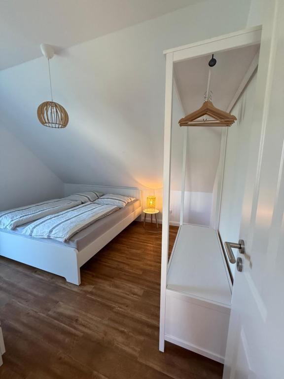 Schlafzimmer mit Dachschrägen, Bett, Kleiderschrank und Lampe.