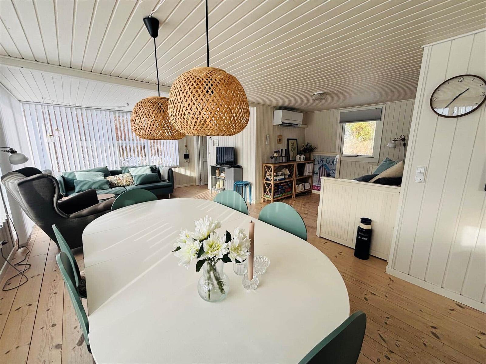 Essbereich mit runden Tisch und Stühlen, Wohnbereich mit Sofa und Deckenventilator.